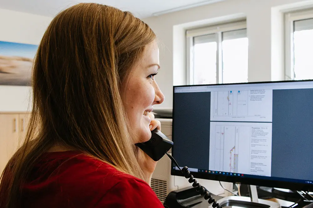 Dispatch team member on the phone in front of a screen showing plans